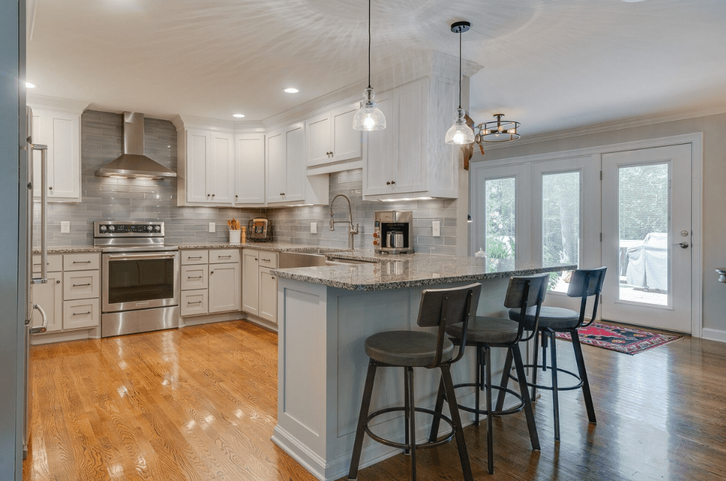 Modern kitchen with white cabinetry and island seating.
