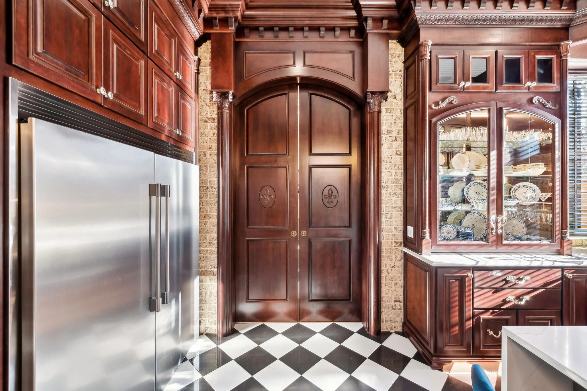 Elegant kitchen corner with wooden cabinetry and checkered floor.