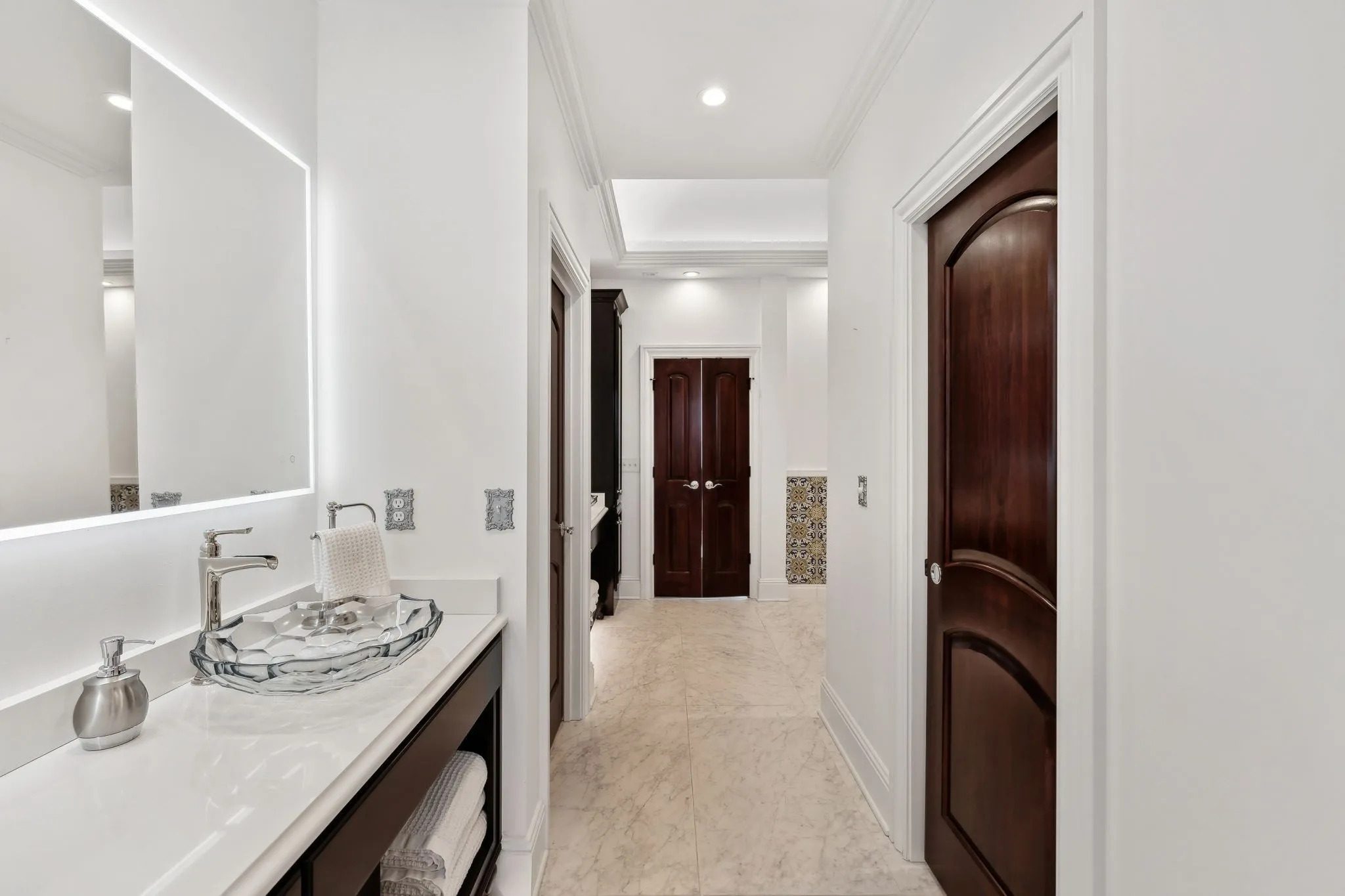 Modern bathroom with a clean, minimalist design and dark wood doors.