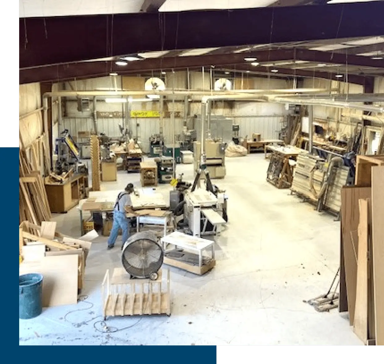 Spacious woodworking workshop with various tools and wood materials.